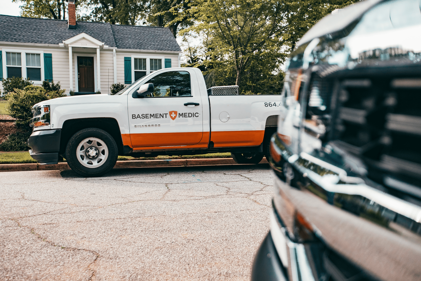 Basement Medic truck on a residential driveway, ready to start an interior basement waterproofing job