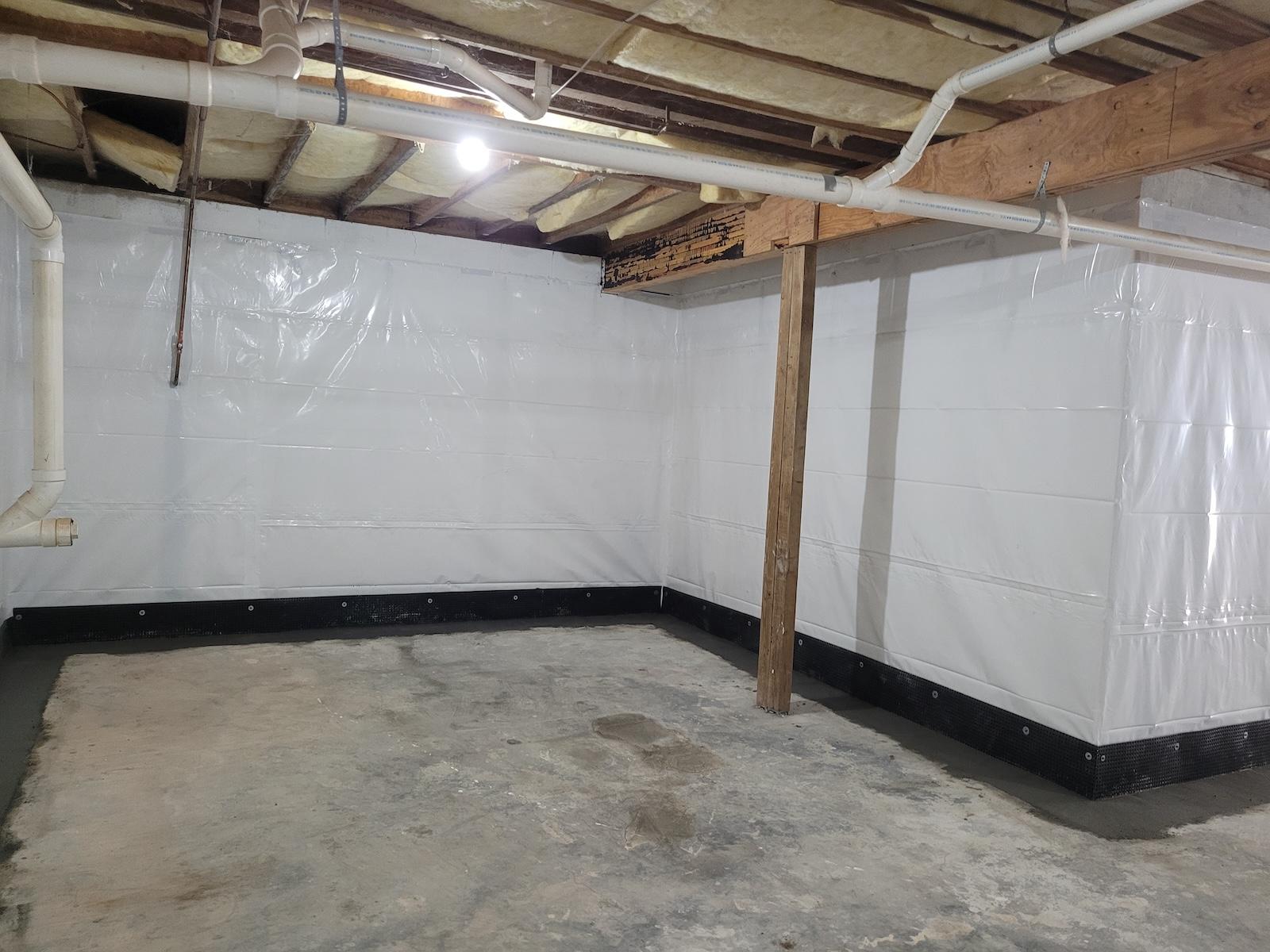 Completed Basement Medic interior waterproofing job: fresh concrete poured flush along the perimeter where the subslab drain was installed beside and below the footer